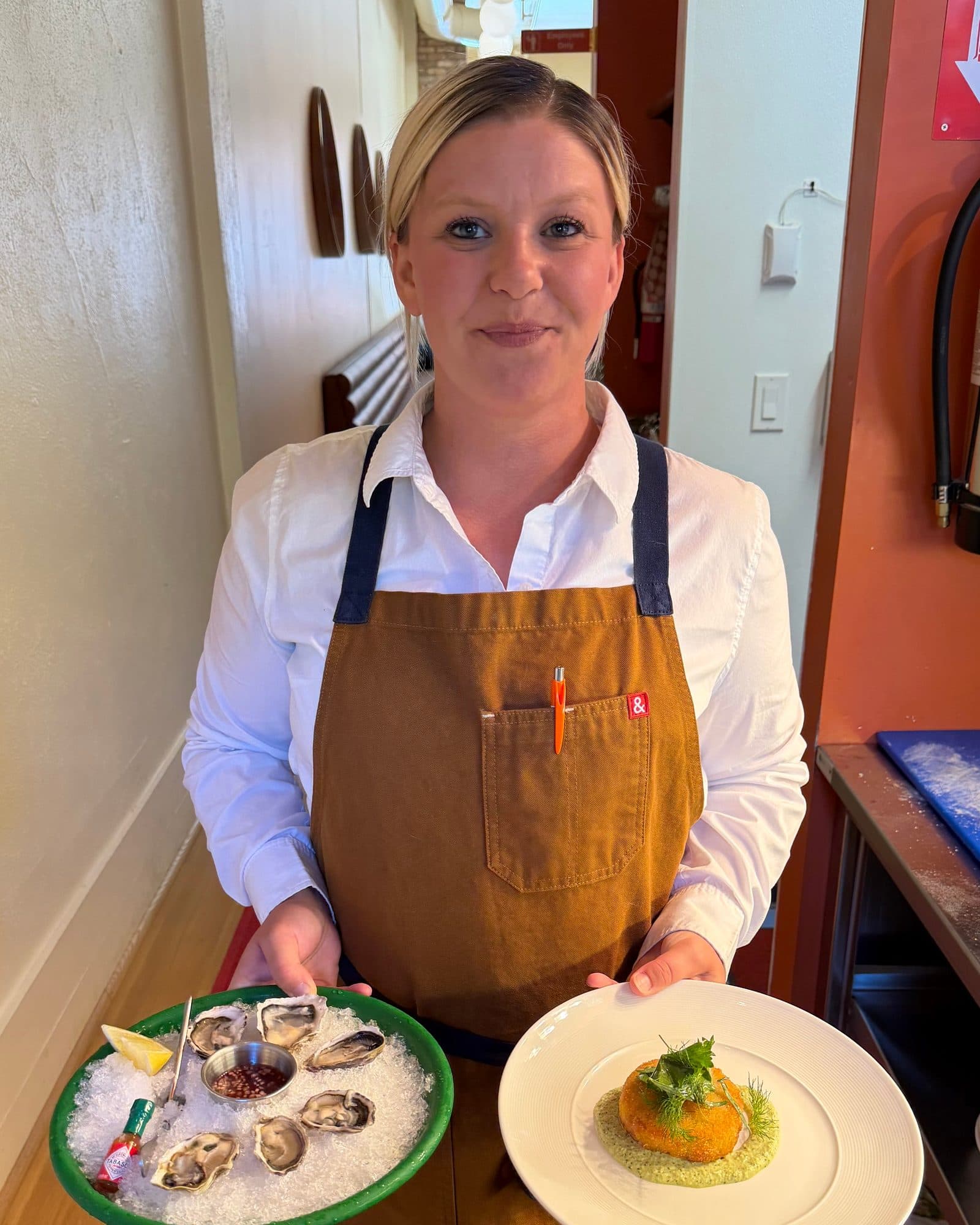 Lacey holding oysters on ice and a Dungeness crab cake